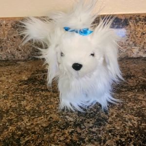 The stuffed animal is super cute with blue bow